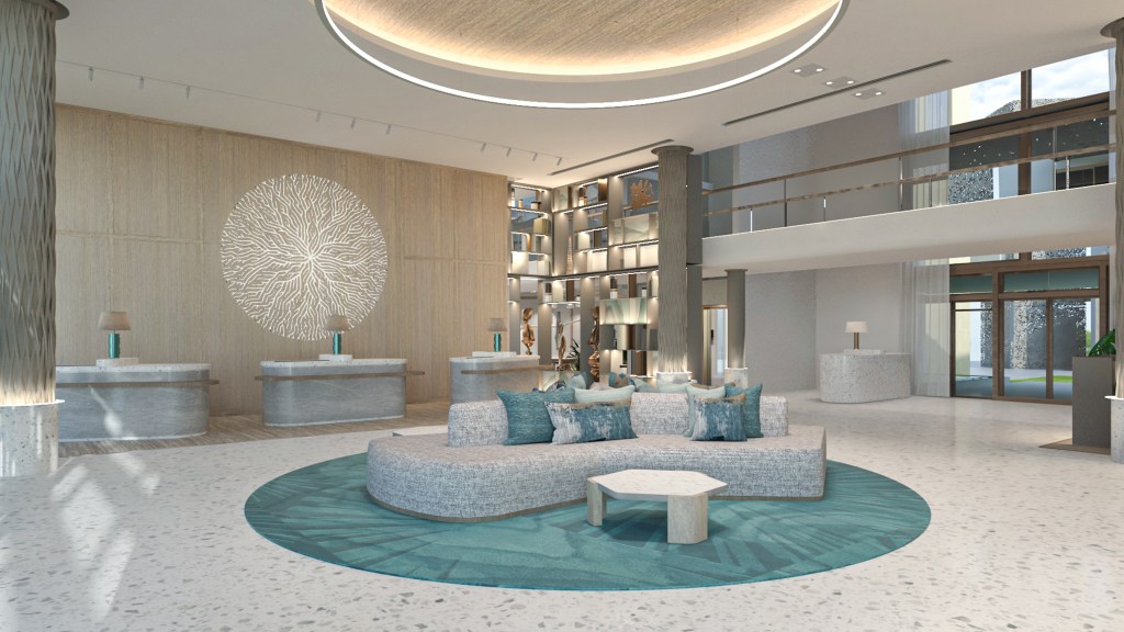 grey and teal lobby area with couch, coffee cable and three reception desks, view of entrance and second floor balcony