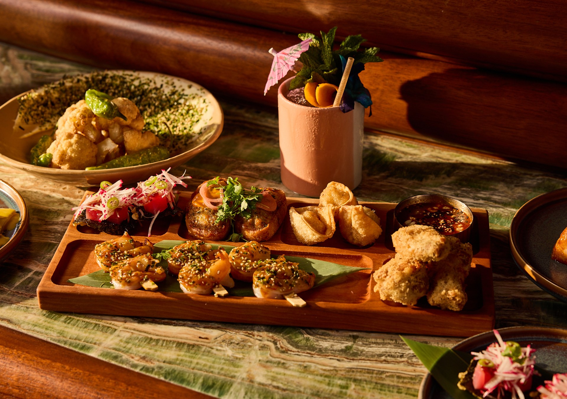 Papaya Club at Conrad Orlando, appetizers - shrimp, rangoons, and plates of food, a beverage with an umbrella and garnish