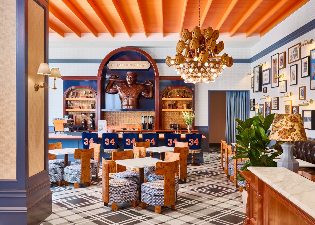 Graduate by Hilton Auburn, AL - Bo Jackson’s Beans featuring a hand-carved wood statue of Bo Jackson with barstools displaying his football jersey number, 34, and a variety of seating around the cafe