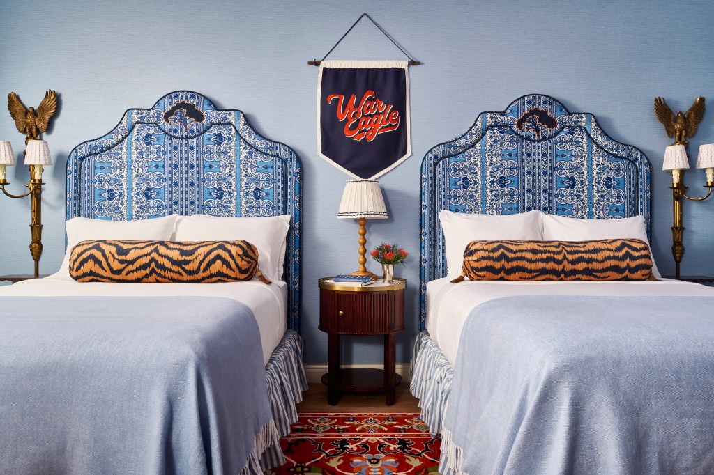 Graduate by Hilton Auburn, AL - Guest Room Details - two white and blue beds with tiger print bolster pillows, War Eagle artwork, brass eagle lamps