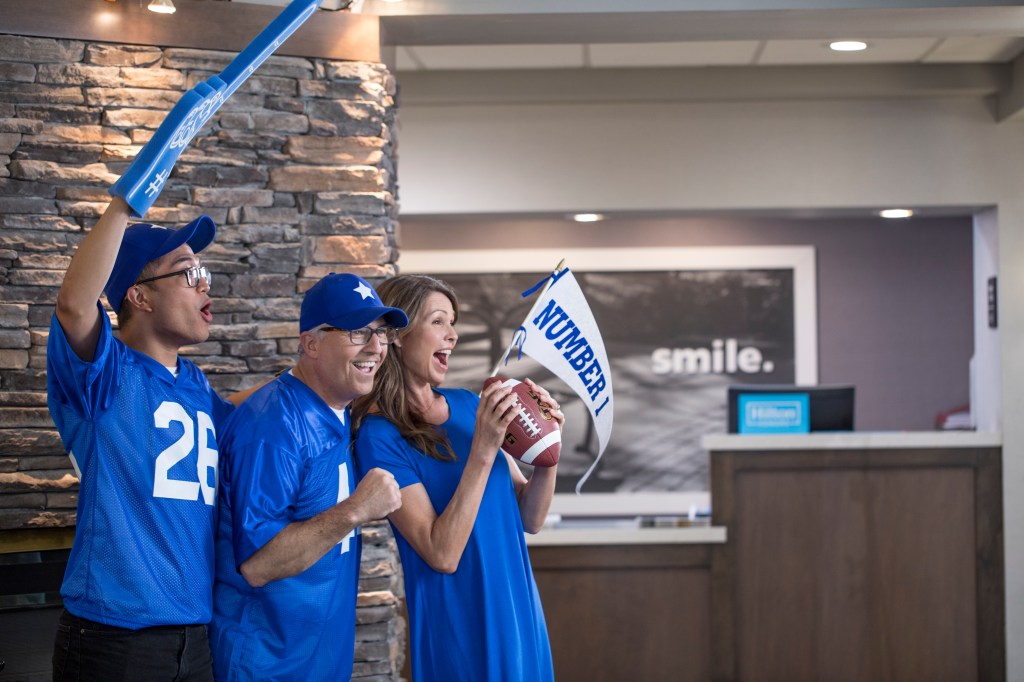 3 sports fans dressed in blue in hotel lobby