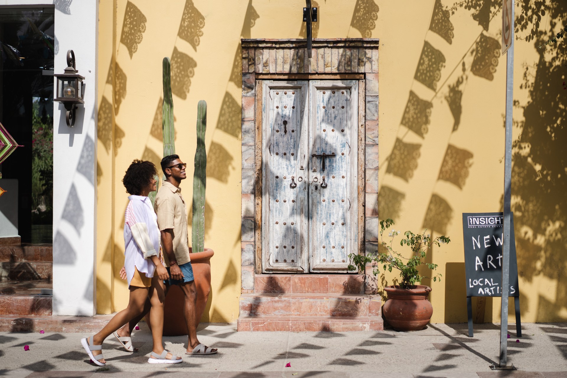 two people on a walk, sidewalk, sunglasses, shorts, sandals,