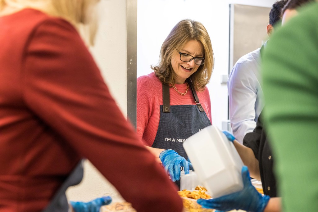 London, England - The Felix Project - group of volunteers wearing aprons sorting food