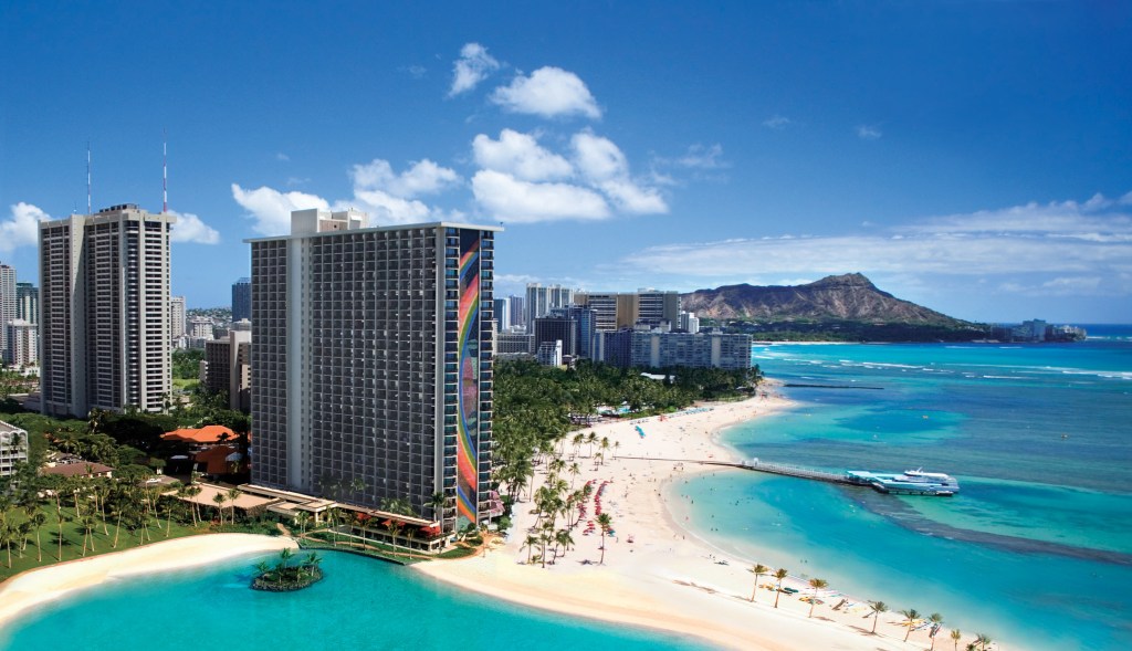 Hilton Hawaiian Village Waikiki Beach Resort - Aerial image with hotel, beach, ocean and mountains in the distance