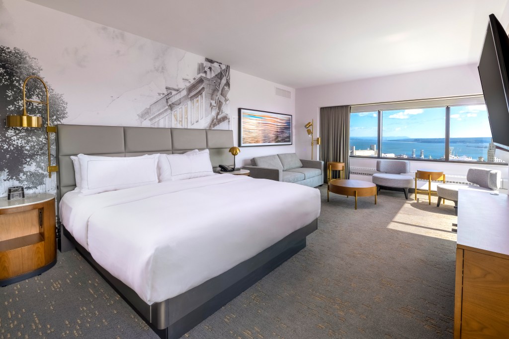 Hilton Quebec - Guest Room - bed, black and white art mural on the wall, large window overlooking the water