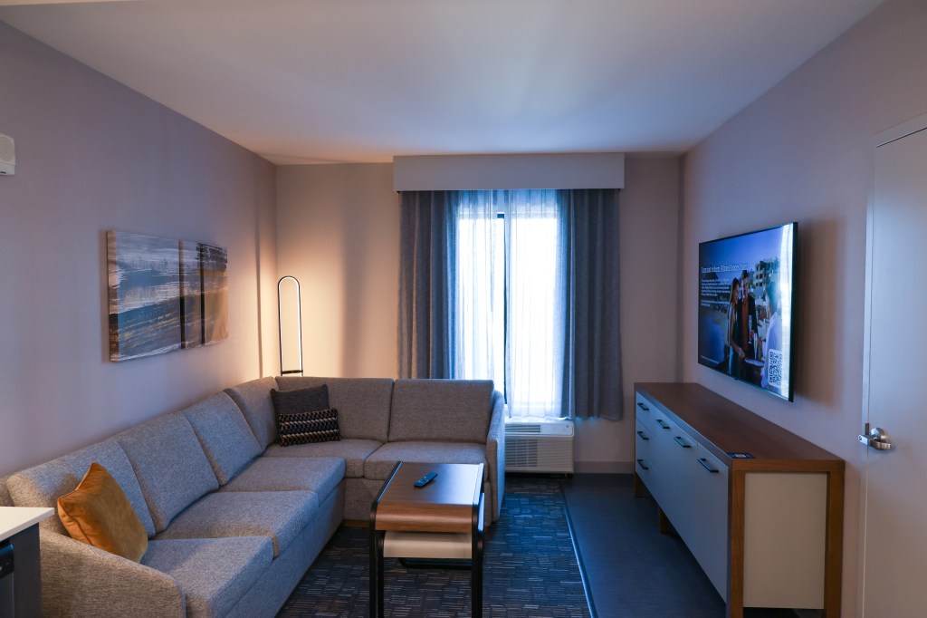 Homewood Suites by Hilton Raleigh Downtown - Guest Room, large living room area with sectional couch, coffee table, entertainment center and tv