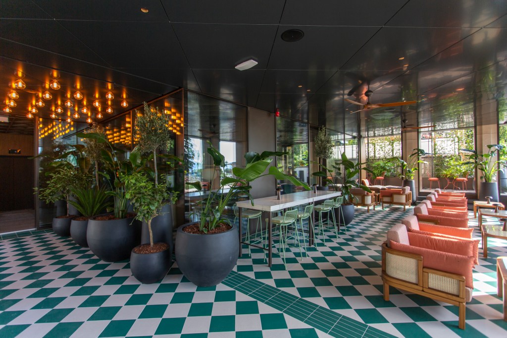 Keight Hotel Opatija Curio Collection by Hilton - Lobby, green and white tiled floor, black planter pots, teal bar stools, taracotta pillows, lounge seating, potted plants, wooden ceiling fan, marble high top table, black ceiling, bulb lit entry way