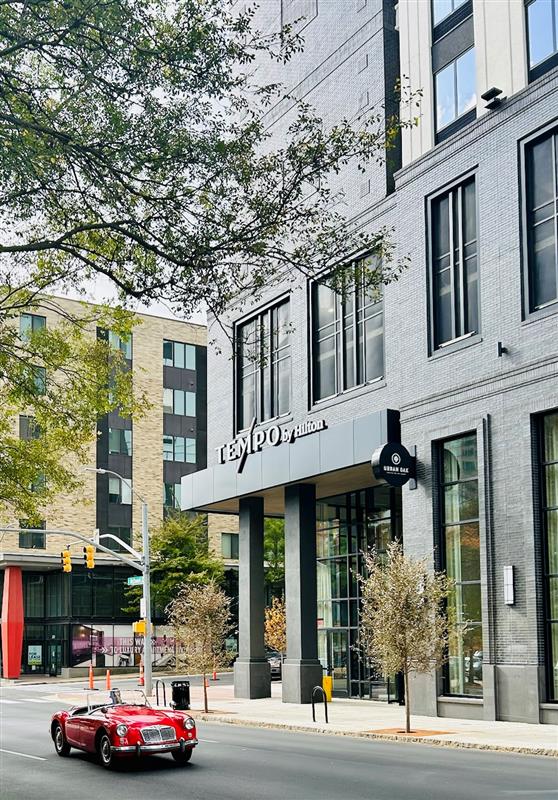 Exterior of Tempo by Hilton Raleigh Downtown with a red classic car driving by