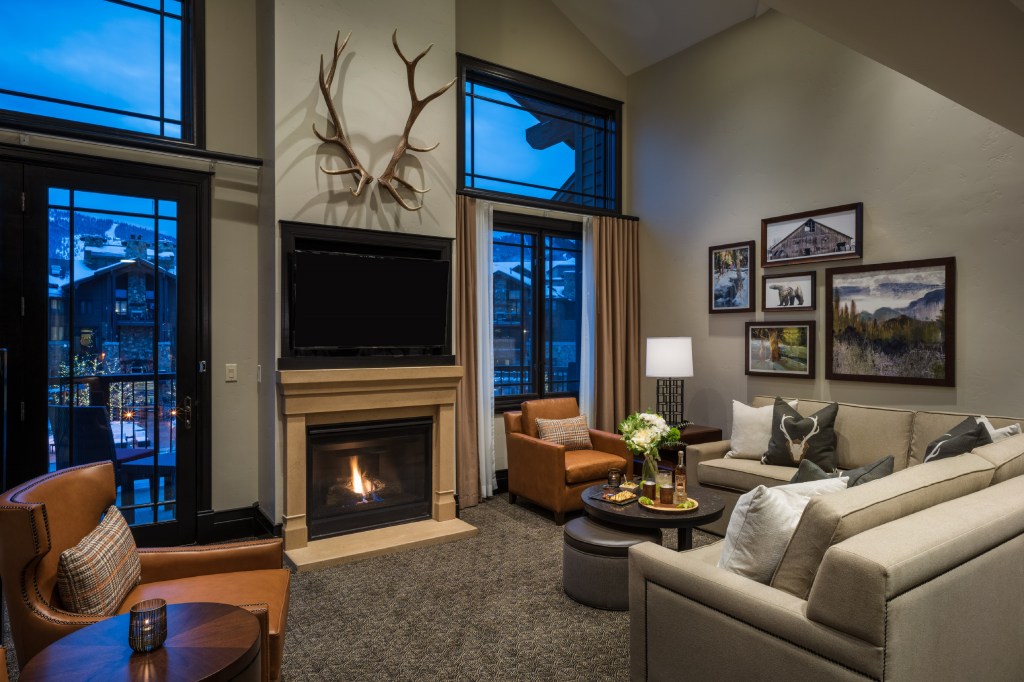 Waldorf Astoria Park City - Bi-Level 2 Bedroom Suite, living room area with couches, chairs and tables, tv over a fireplace, mounted antlers