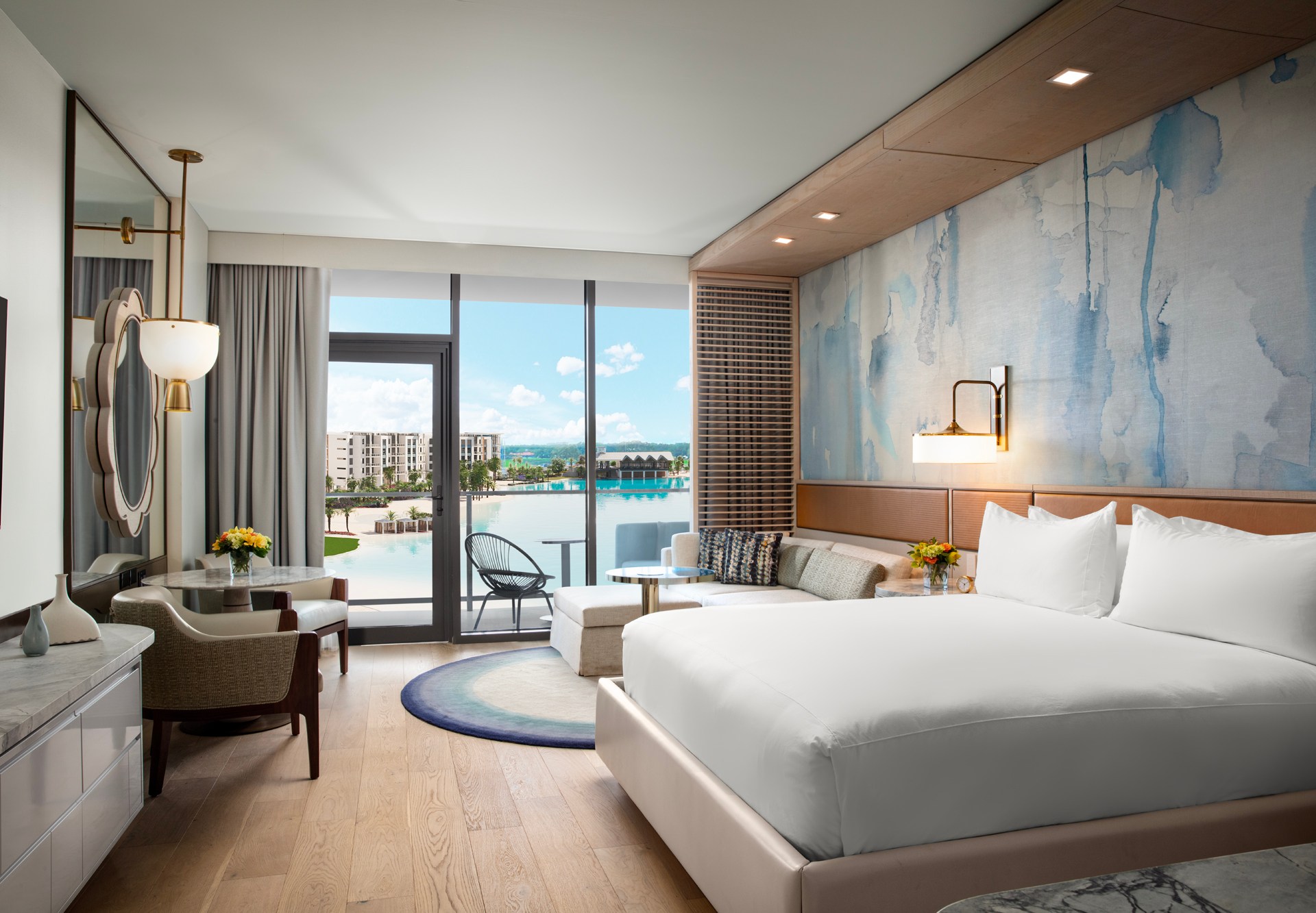 Conrad Orlando, King Guest Room Lagoon View, sconce light, gold pendant light, accent mirror, decorative wall, white bedding, marble table top, chaise couch, accent chairs