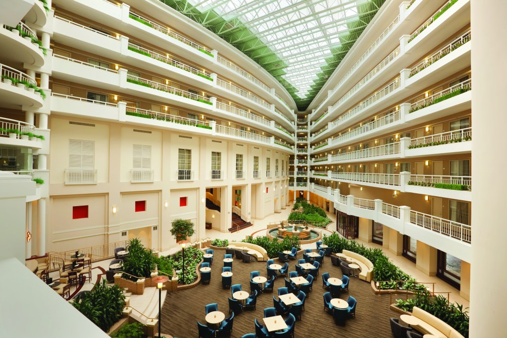 Embassy Suites Alexandria Old Town, Atrium, sitting area, balcony hallway, indoor plants, blue chairs, bench seating, potted plants