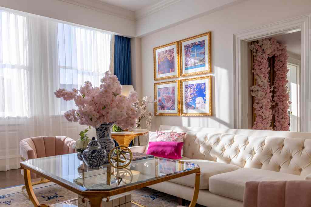 Waldorf Astoria Washington DC, Cherry Blossom Suite, decorative vase, white couch, pink accent chair, framed pictures, glass coffee table, pink accent pillows