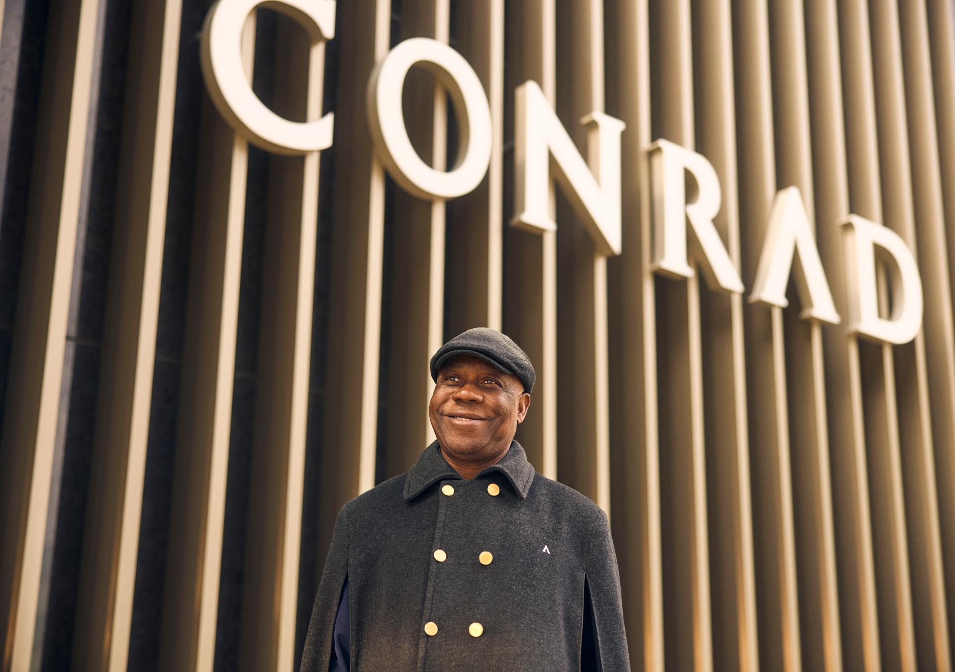 Conrad Nashville Team Member smiling in front of sign