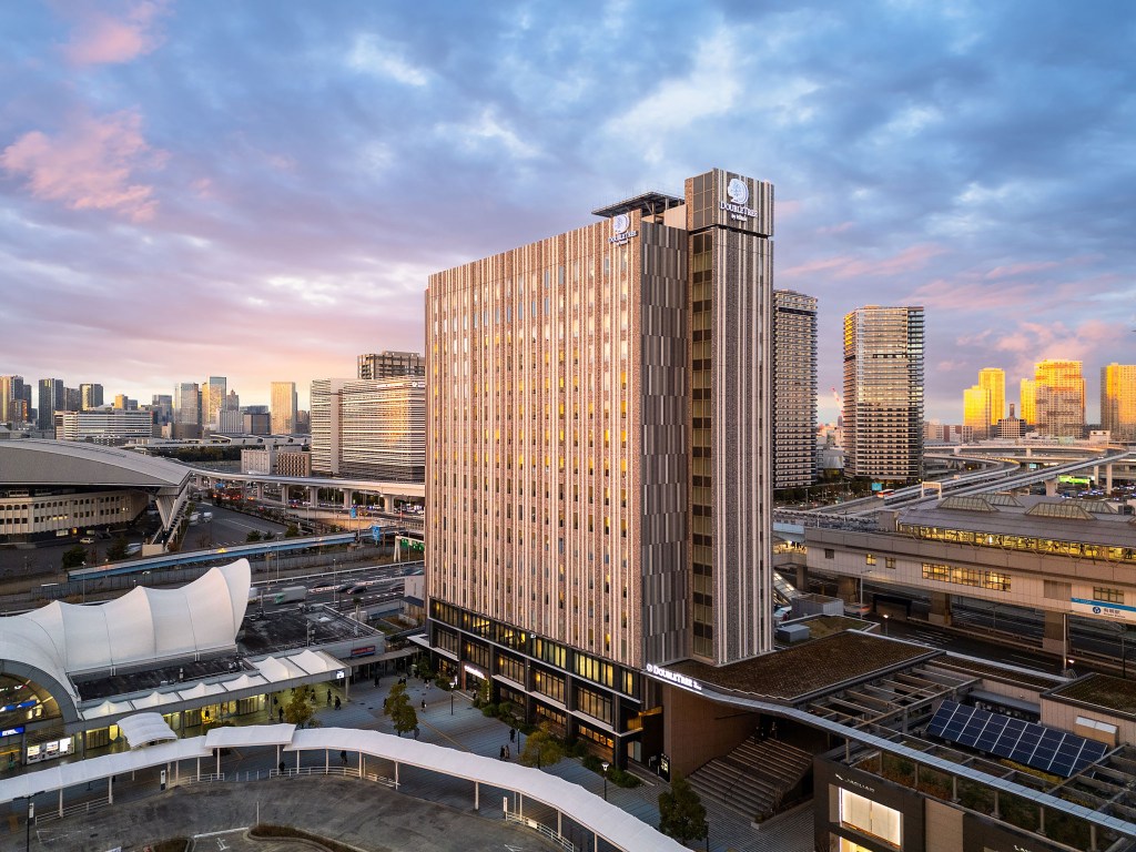 DoubleTree by Hilton Tokyo Ariake Exterior of building with colorful clouds in the sky and golden lighting from the sun
