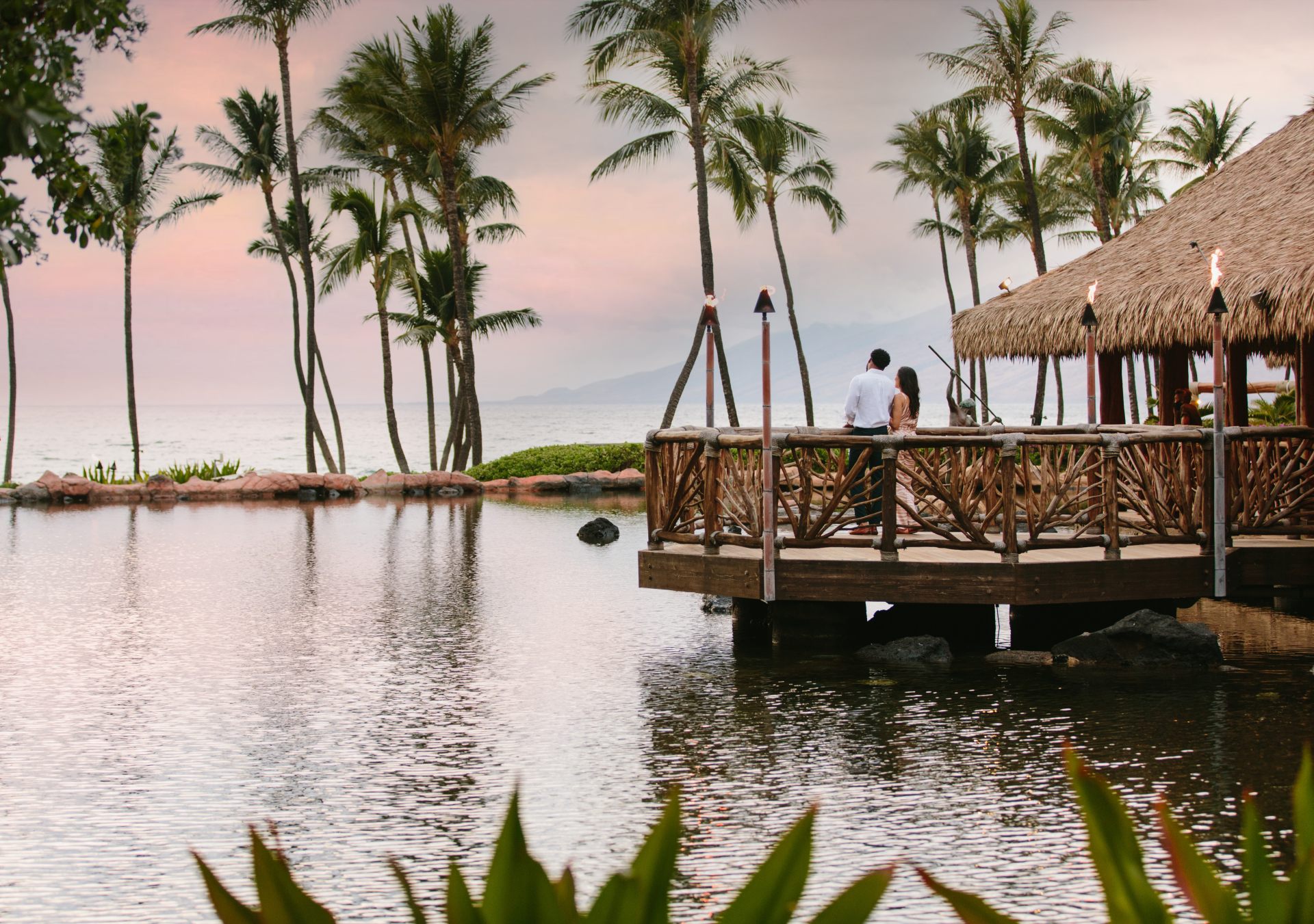 Grand Wailea, A Waldorf Astoria Resort - Sunset - couple looking out at sunset over water with palm trees
