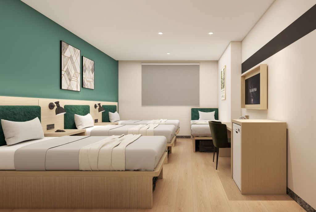 Spark by Hilton Makkah Aziziyah, Four twin beds with artwork hanging on the walls and a desk with a chair and a mini refridgerator