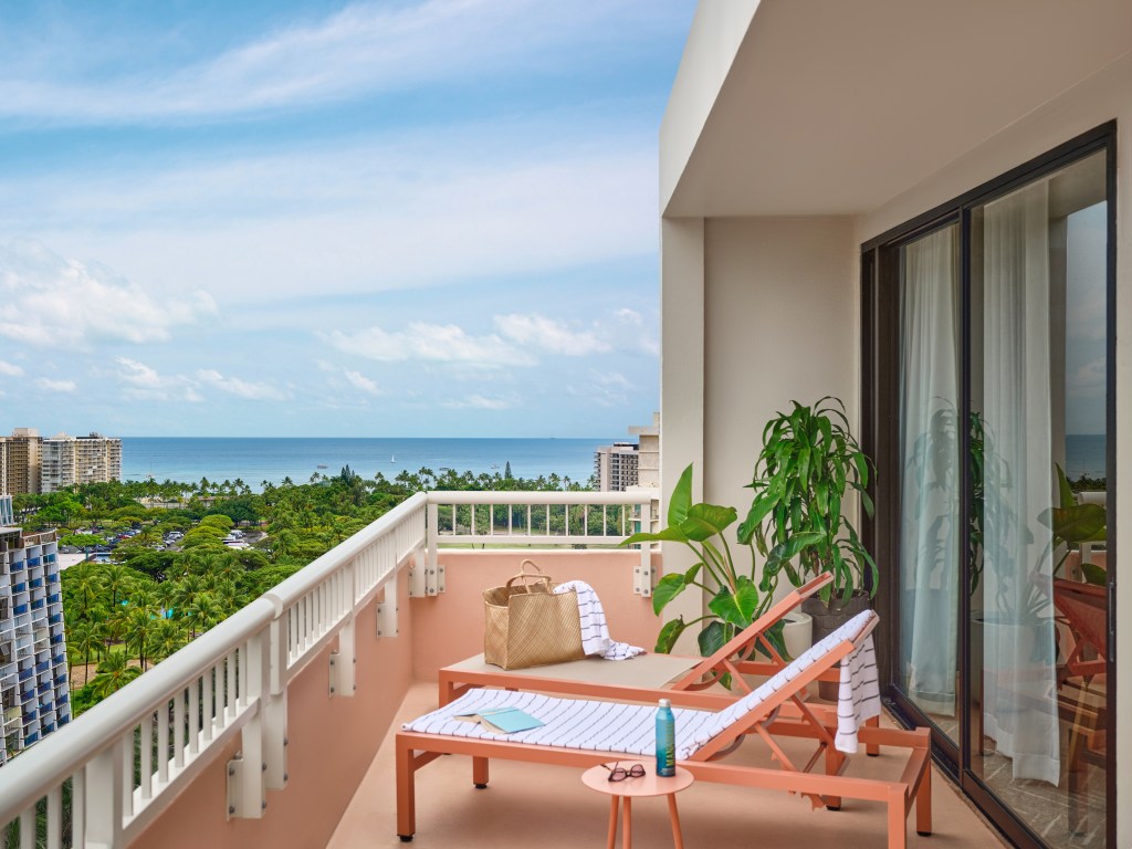The Ambassador Hotel of Waikiki, Tapestry Collection by Hilton - Penthouse Lanai - Credit - Michael Clifford, balcony view of ocean with two lounge chairs, plants and side table