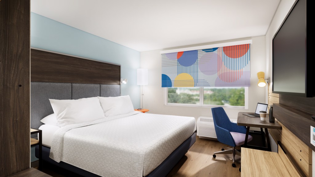 Tru by Hilton, Guest Room, Bed with orange nightstand, Desk with colorful chair, colorful window blinds