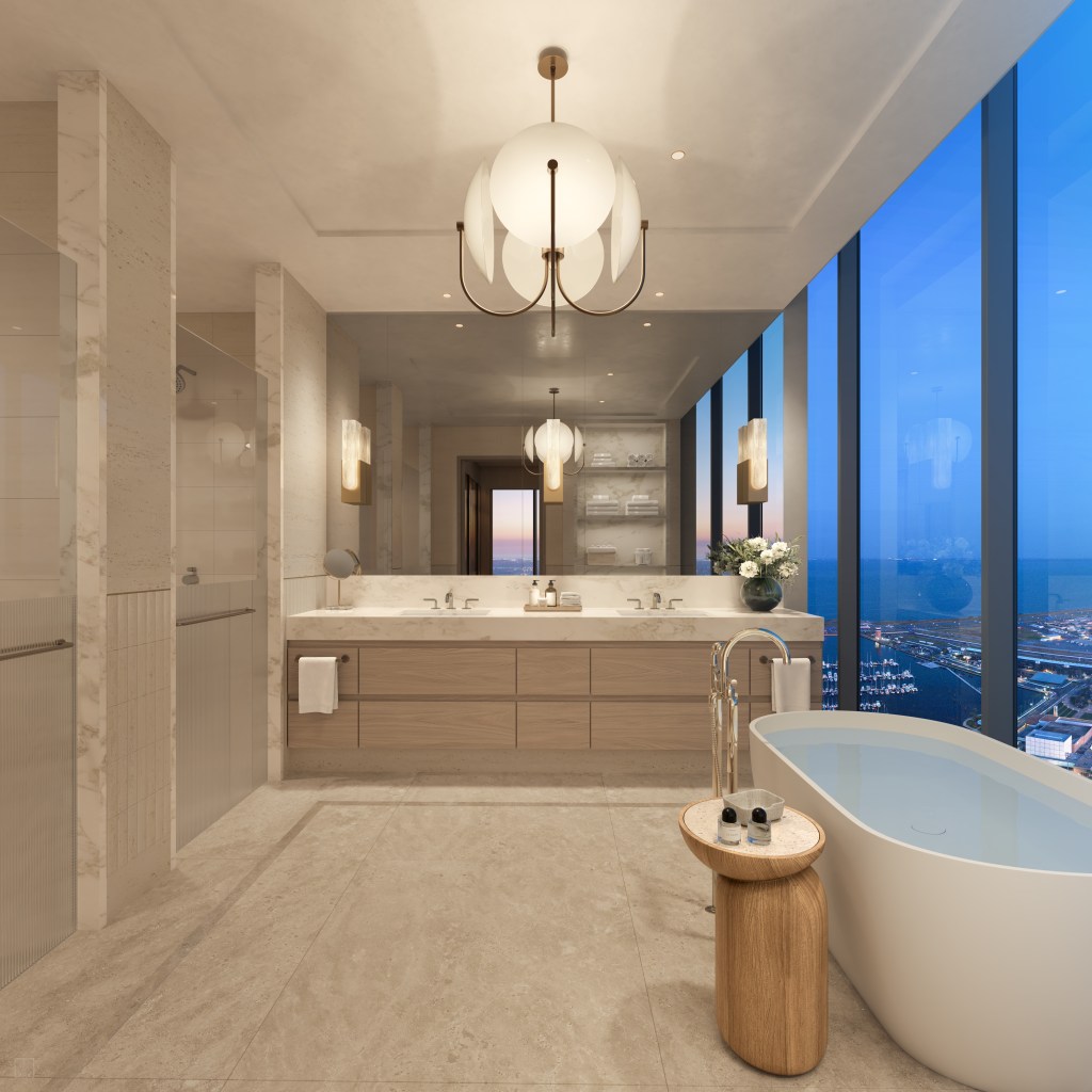 Primary Bathroom with double vanity and a soaking tub with a table and windows overlooking city with view of the water
