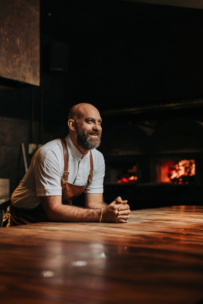 Chef Dave Pynt at a table with fireplace in the background
