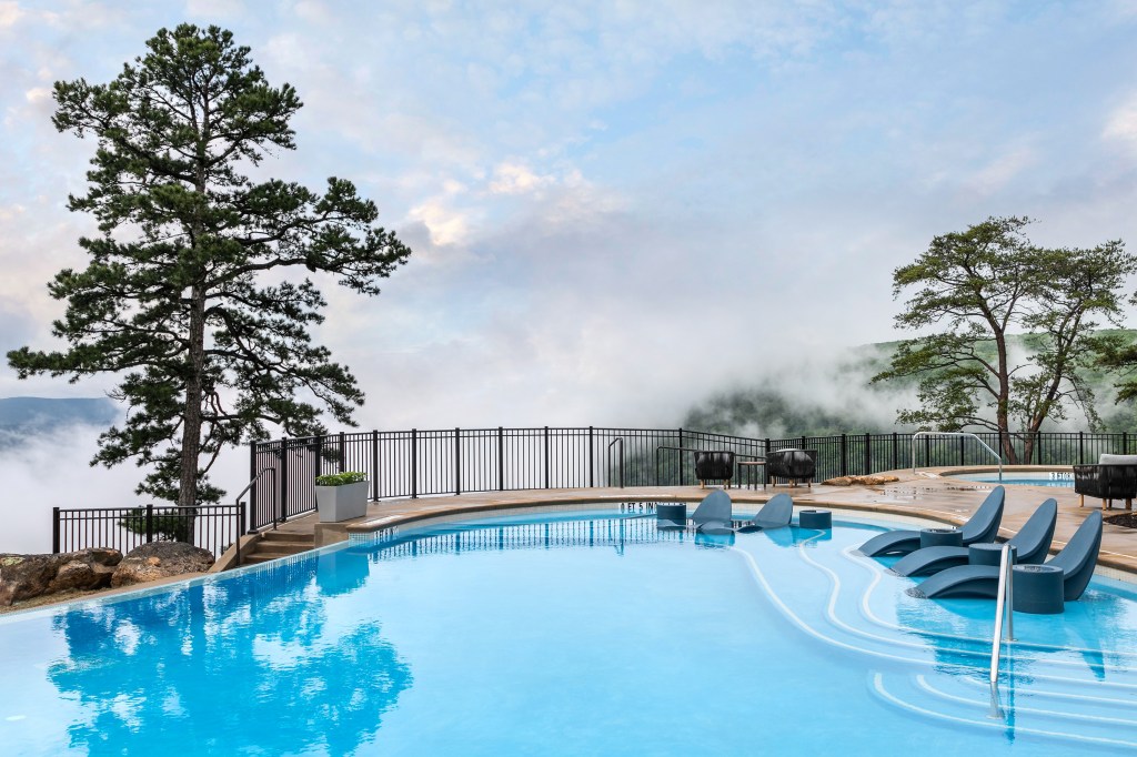 Cloudland at McLemore Resort Lookout Mountain, Curio Collection by Hilton Pool with lounge chaise seats in the shallow water and lounge chairs on the pool deck overlooking the view
