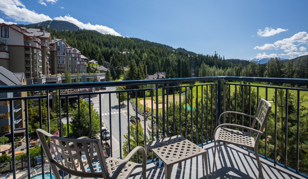 Hotel Exterior View from Balcony with two chairs and a table overlooking mountains and a golf course