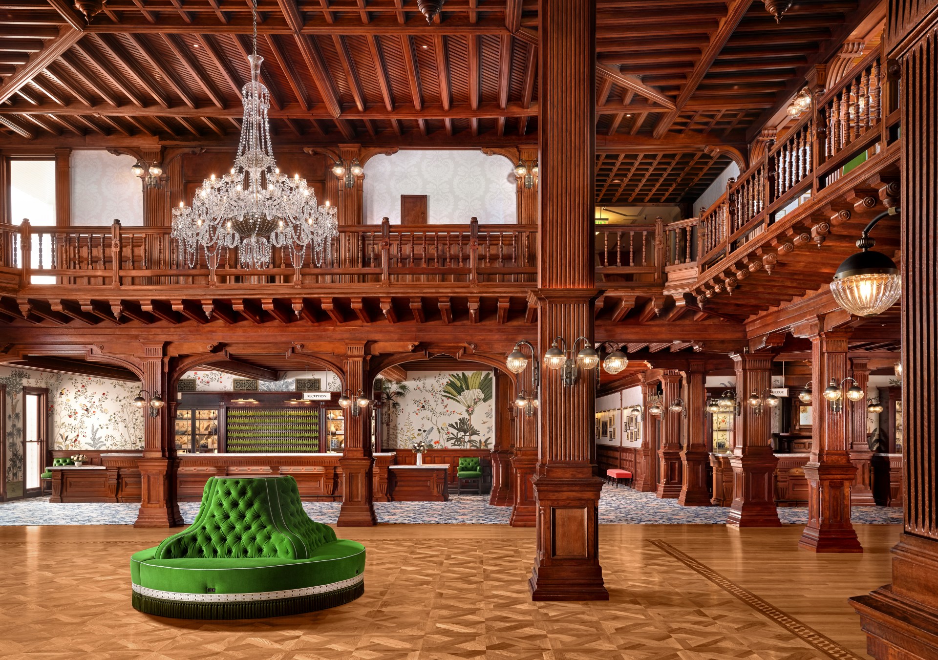 Hotel del Coronado Lobby restored with exposed wood throughout and a chandelier hung over a green circular accent chair