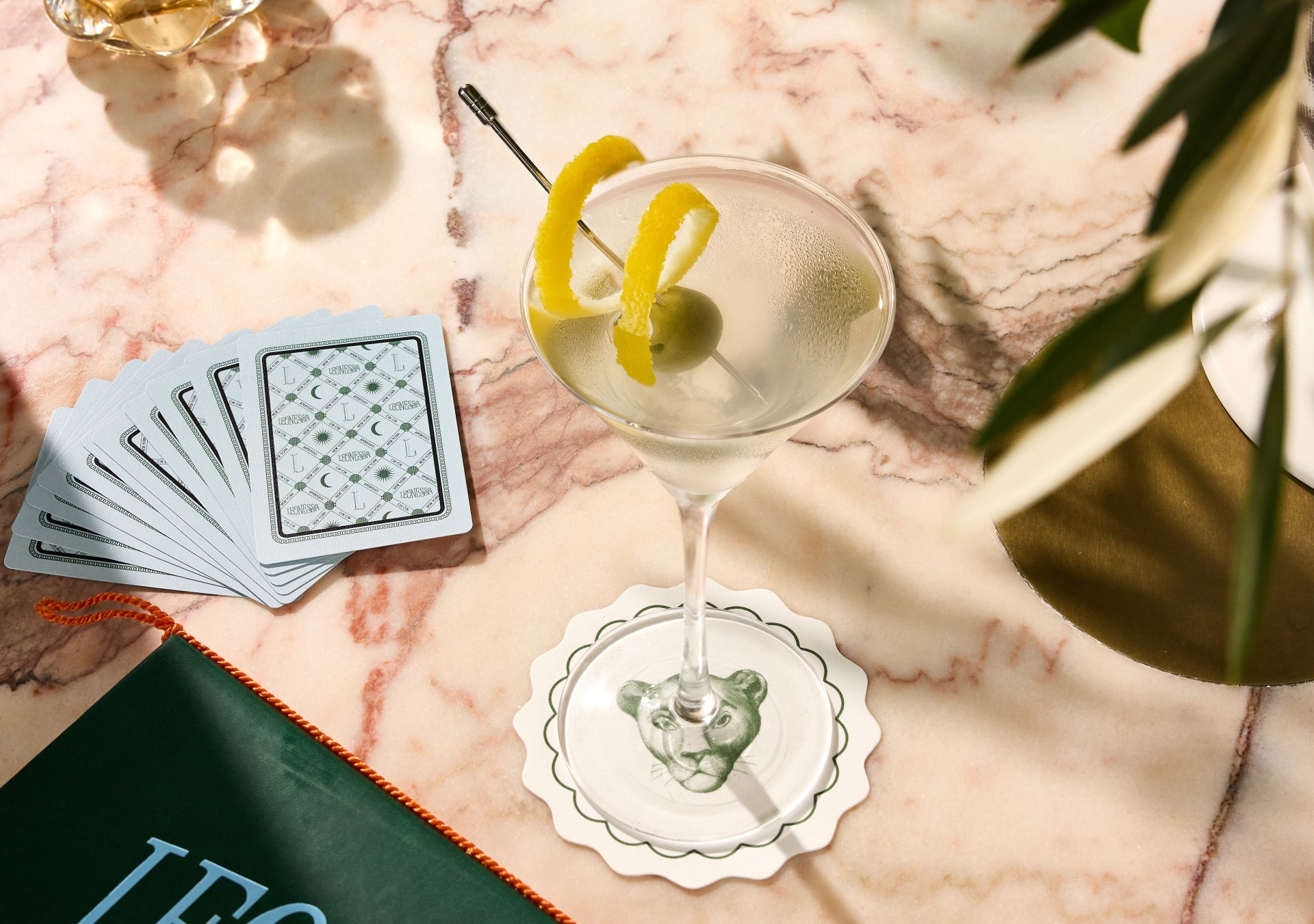 Leonessa Martini with lemon twist surrounded by a deck of cards, a Leonessa menu and a coaster - Photo credit Michael Persico Courtesy of Conrad New York Downtown