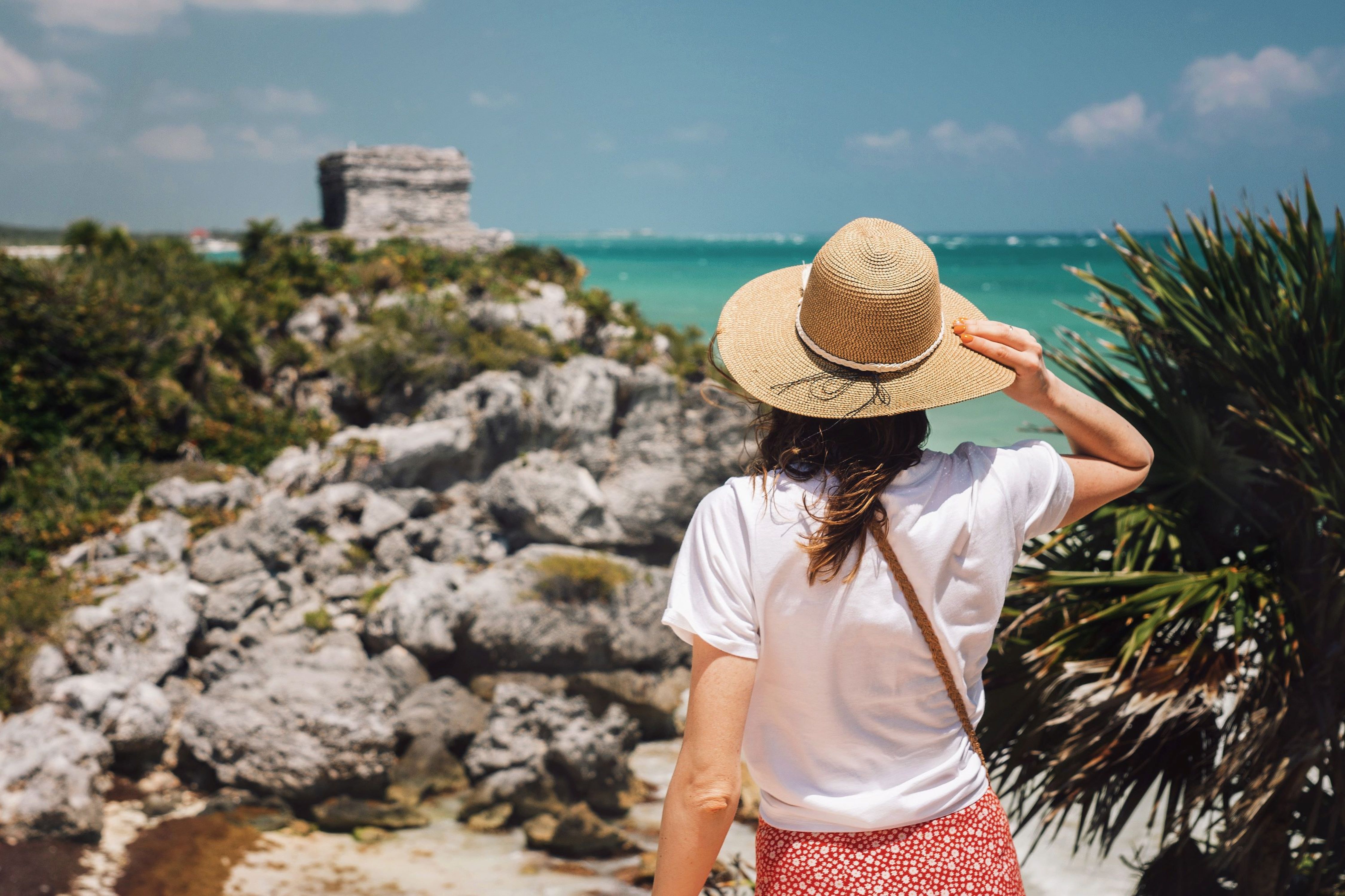 Conrad Tulum Riviera Maya - Tulum Ruins - woman wearing a hat overlooking ruins in Tulum, Mexico