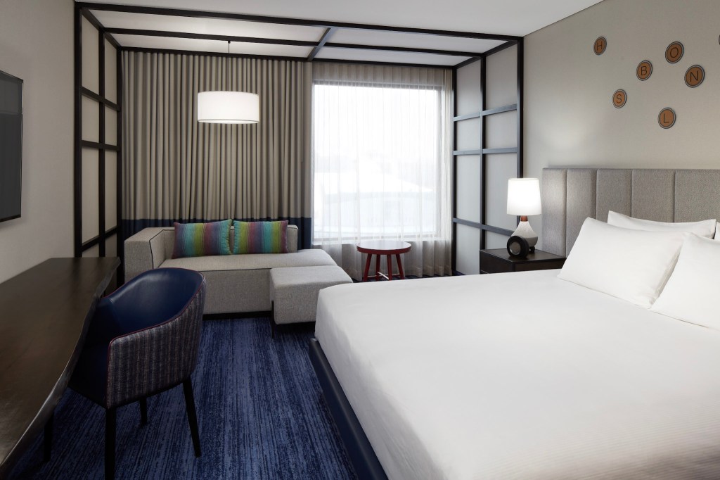 Modern executive guest room at DoubleTree by Hilton Montreal featuring a plush king bed, stylish workspace, and cozy lounge area, perfect for a relaxing city stay in any season.