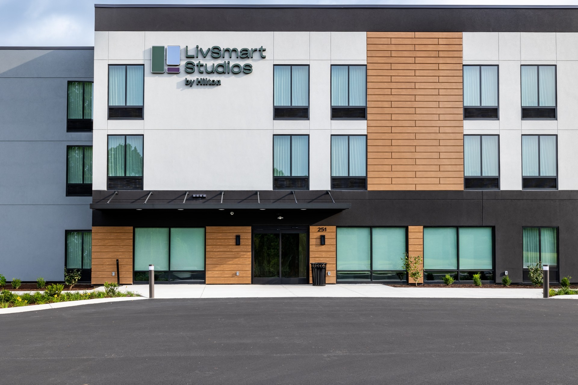 LivSmart Studios by Hilton Tullahoma - Exterior and Entrance - white building with wood, black and light blue accent colors, LivSmart Studios by Hilton sign
