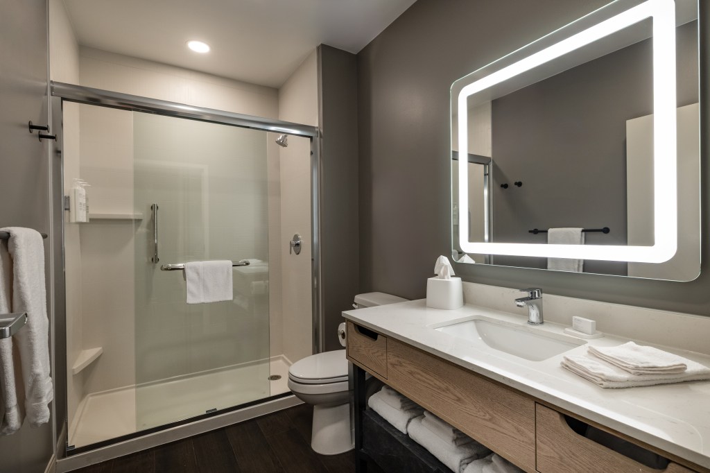 LivSmart Studios by Hilton Tullahoma - Guest Room Bathroom with sink, shower, lighted mirror, grey white and light wood