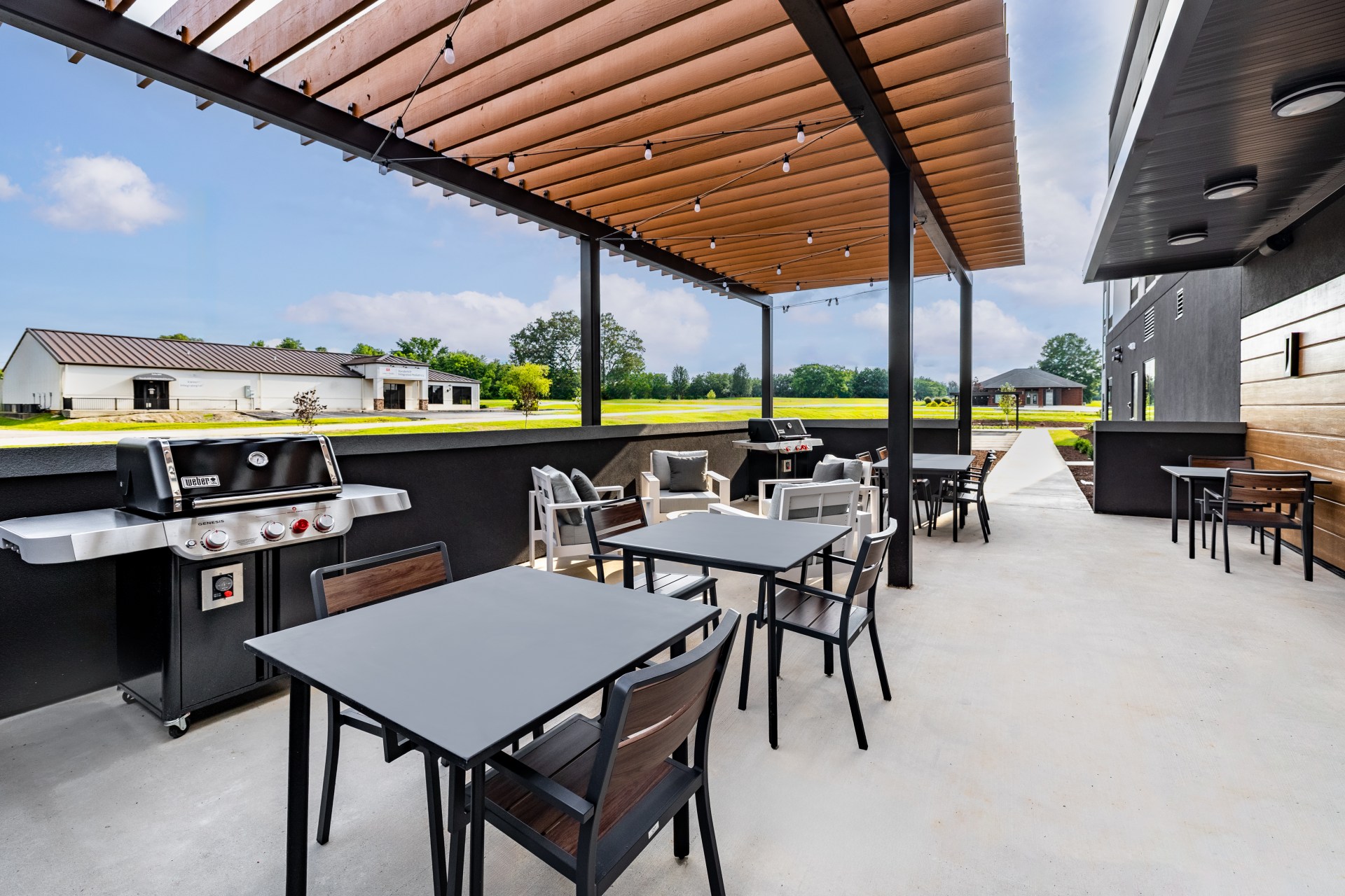 LivSmart Studios by Hilton Tullahoma - Outdoor Patio area with grills, tables and chairs, covered area with hanging lights