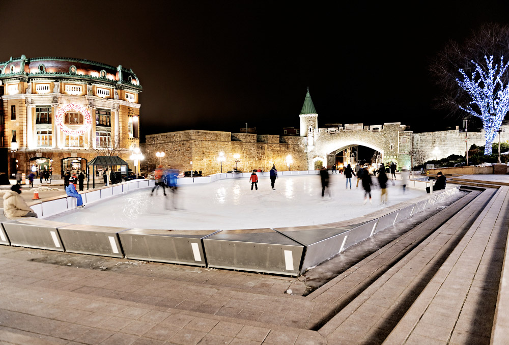 People skating at Place d’Youville in Old Quebec under festive lights, capturing the enchanting winter spirit of the city.