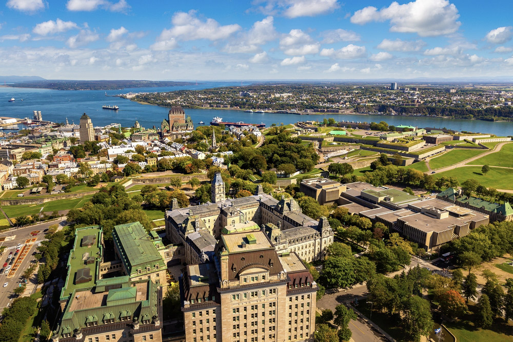 Scenic aerial view of Old Quebec with historic architecture, the Château Frontenac, and the St. Lawrence River, embodying the magic of Quebec across all seasons.