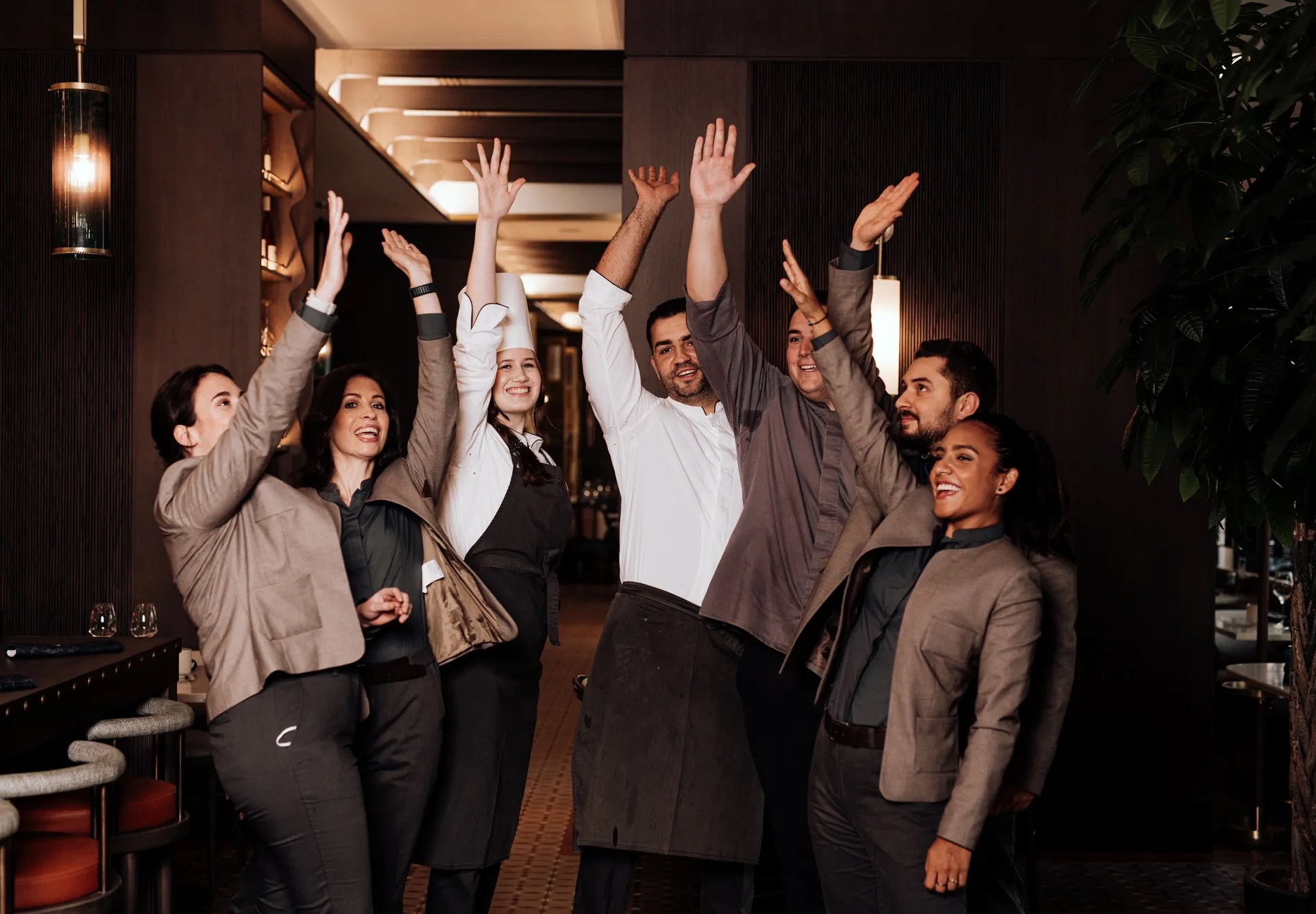 Group of Hilton Team Members Celebrating with a hand raised in the air.