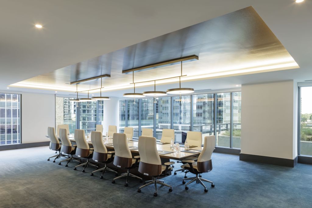 Hilton Arlington Rosslyn The Key Boardroom with conference table with pendant light fixtures above and white conference office chairs with high backs surrounded by windows