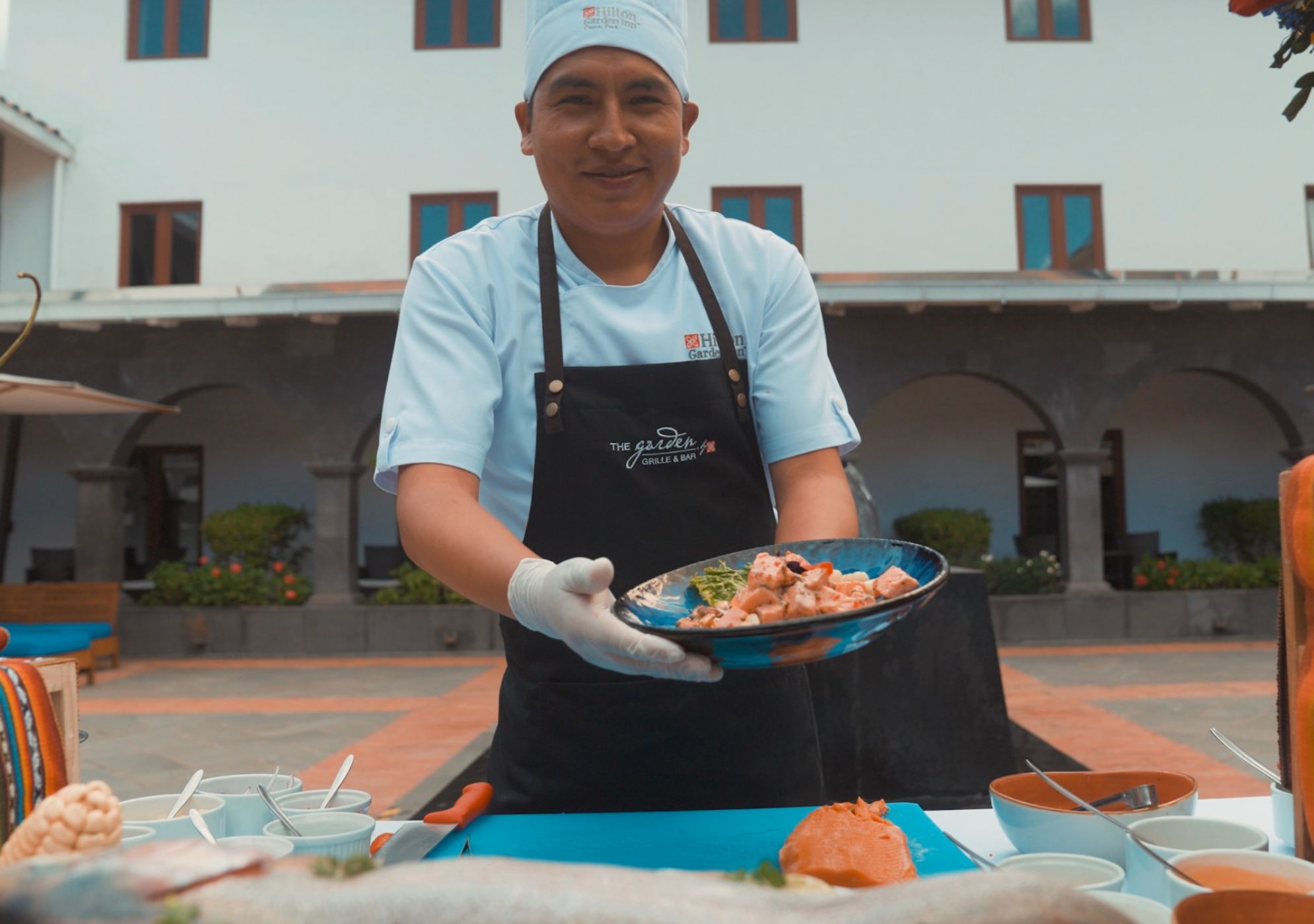 Chef David Huaman Mejia holding a plate of Ceviche at Hilton Garden Inn Cusco