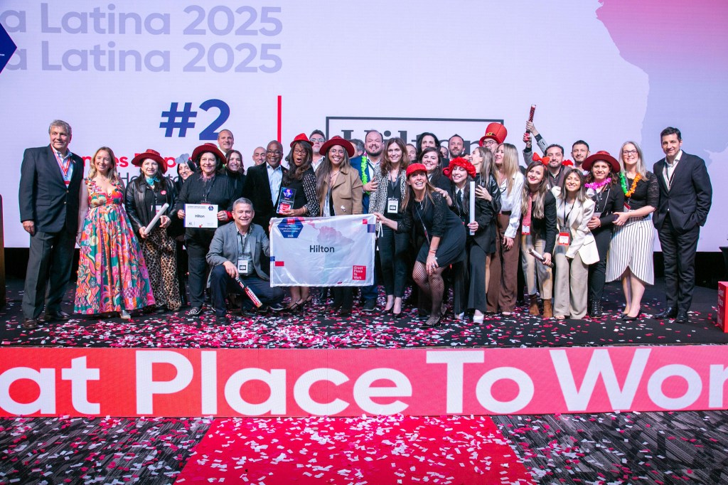 Hilton employees on stage celebrating Best Workplaces 2025 award.