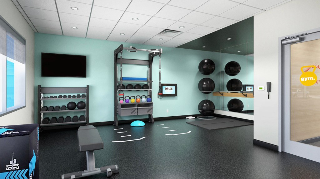 Fitness room with weights, kettlebells, and exercise balls.