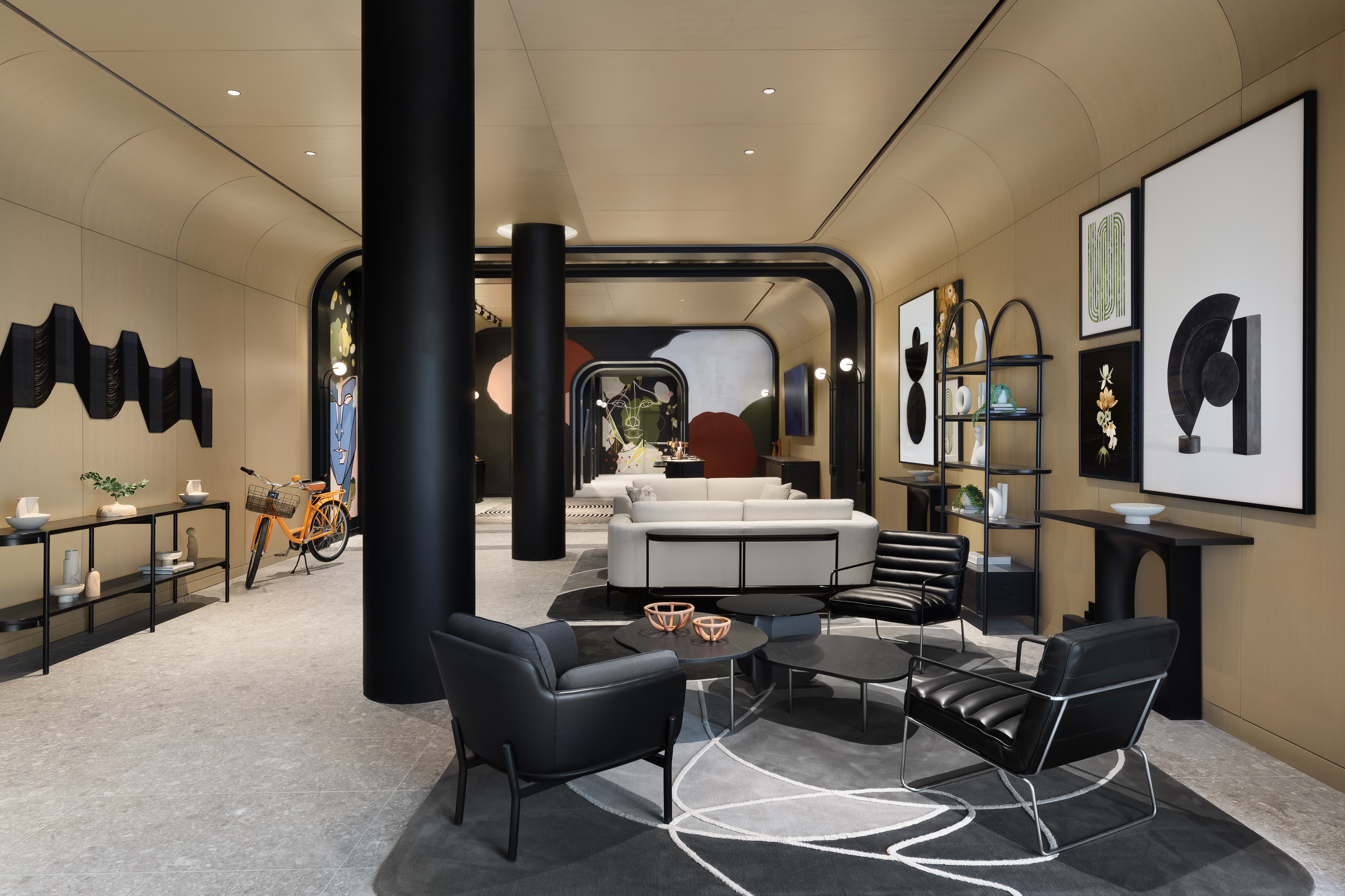 A modern lobby with several seating areas and two prominent pillars dividing the room