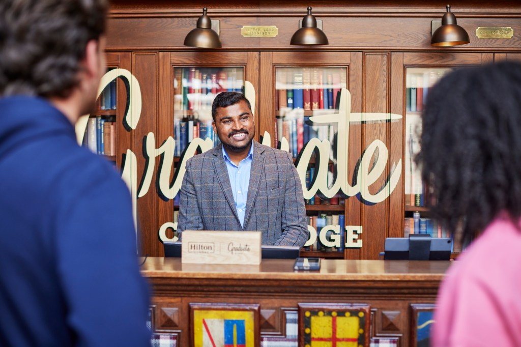 Graduate by Hilton Cambridge - Front Desk, front desk attendant greeting guests