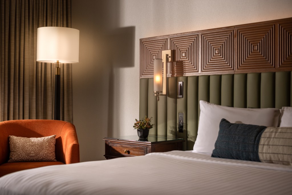 Cozy bedroom with bed, nightstand, and orange chair