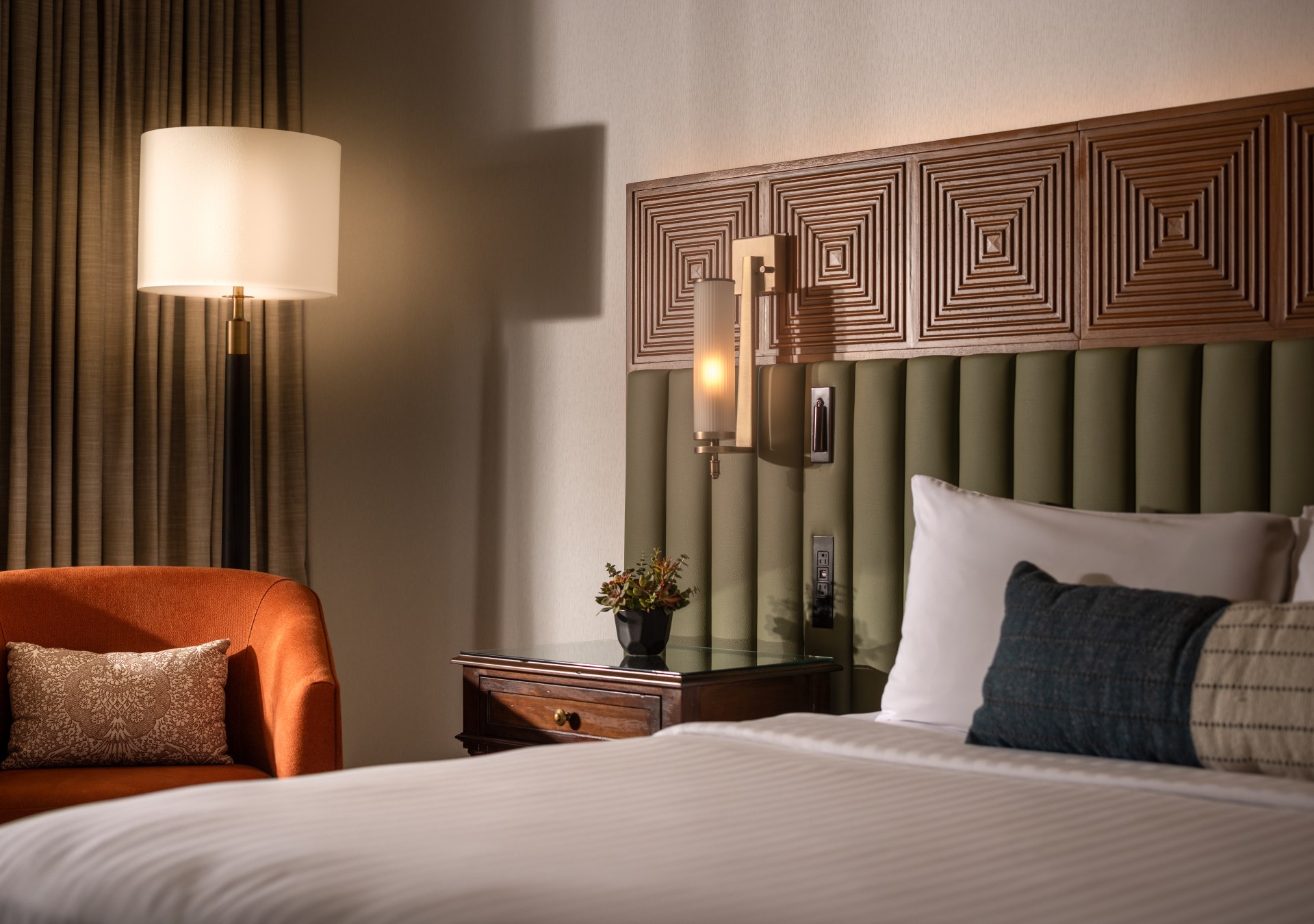 Cozy bedroom with bed, nightstand, and orange chair