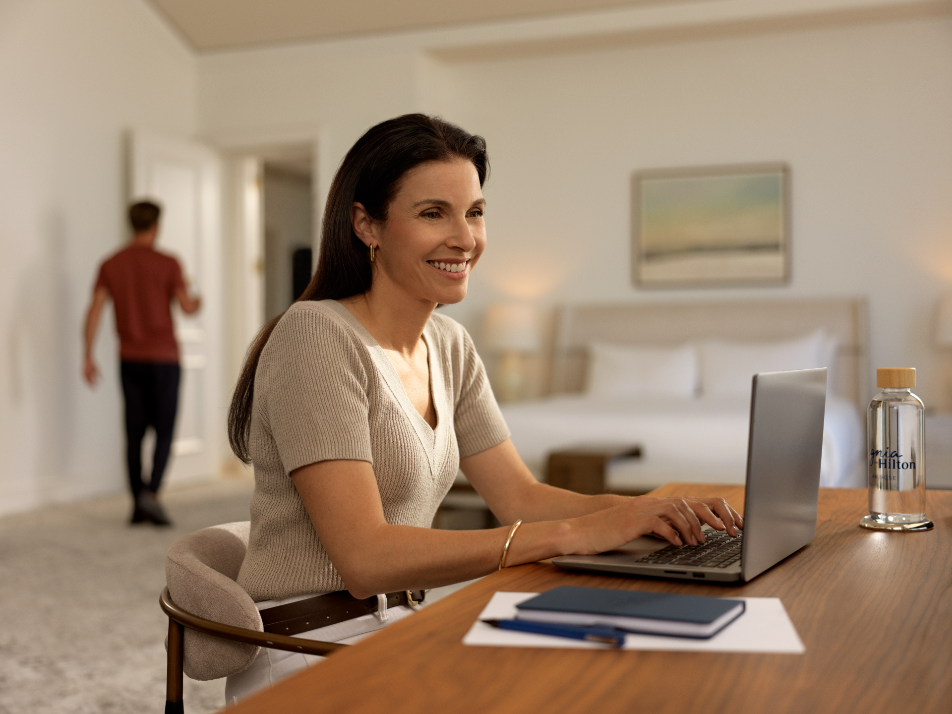 Signia by Hilton San Jose, woman working on laptop at a desk in guest room