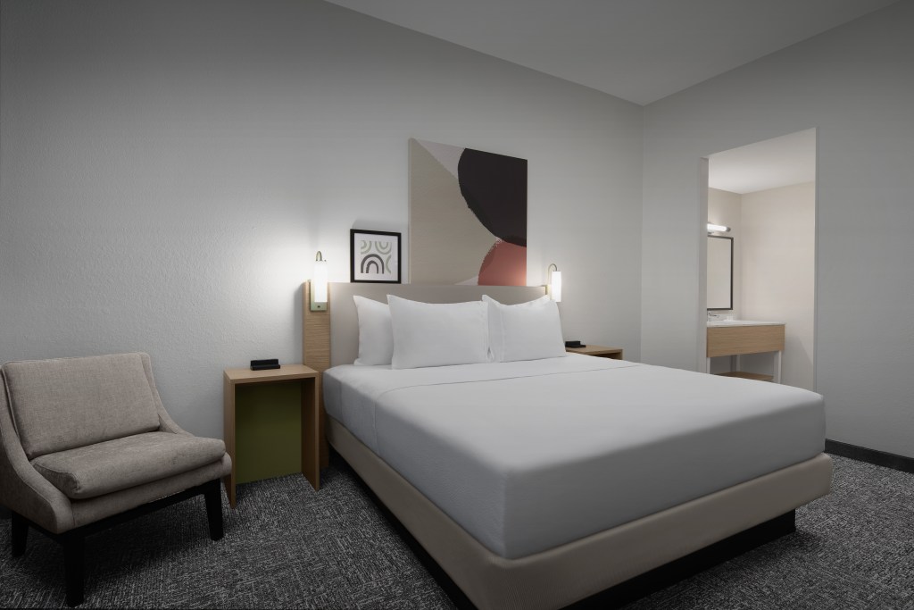 Spark by Hilton Toronto Airport - Guest Room, bed with white bedding, nightstands, colorful artwork on the wall, cream chair