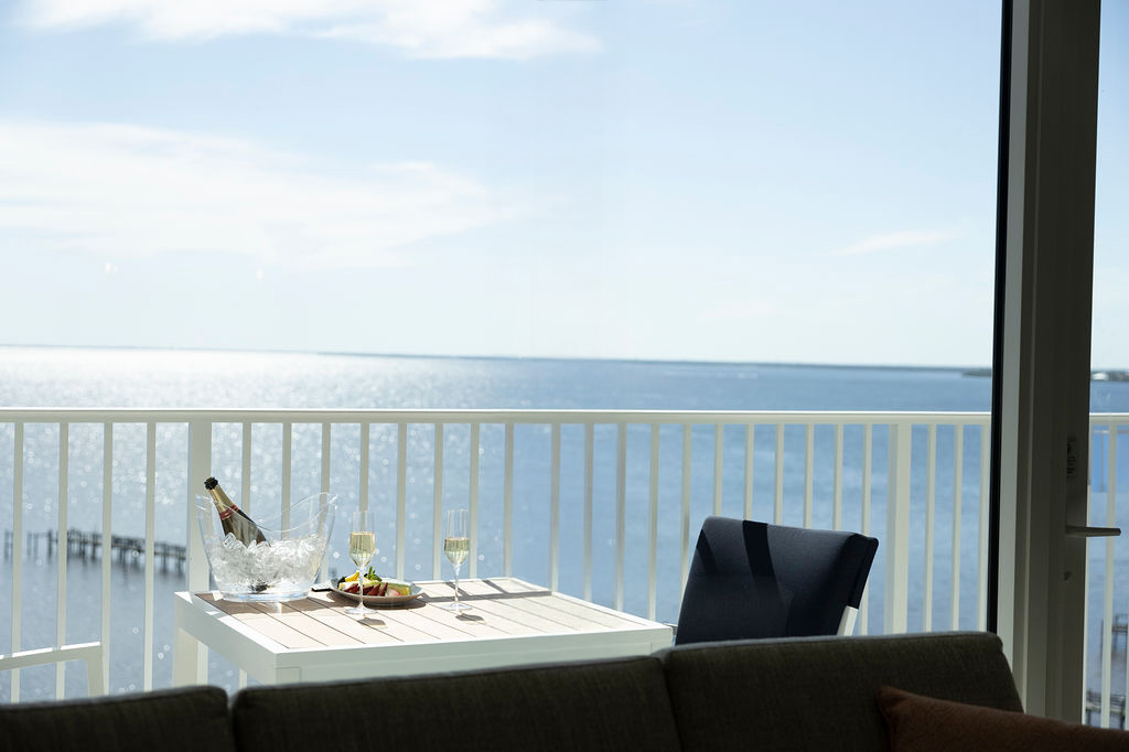 A sunny balcony at the Sunseeker Resort overlooking the ocean, with champagne on the table.