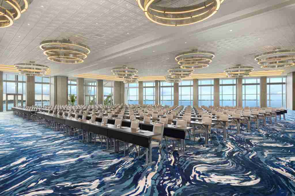 A conference room with many rows of tables and chairs set up for a presentation
