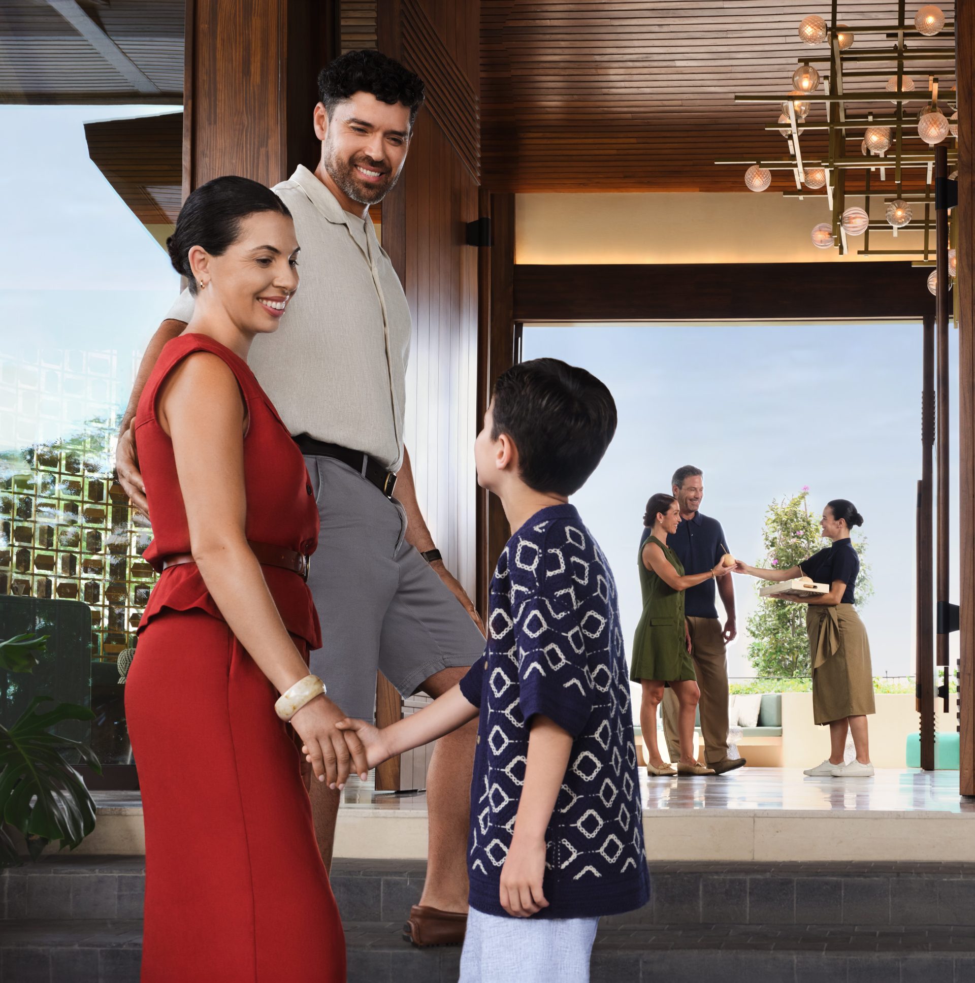 Waldorf Astoria Costa Rica Punta Cacique - Lobby Arrival, family holding hands outside the lobby. Another family in the background being greeted by hotel concierge