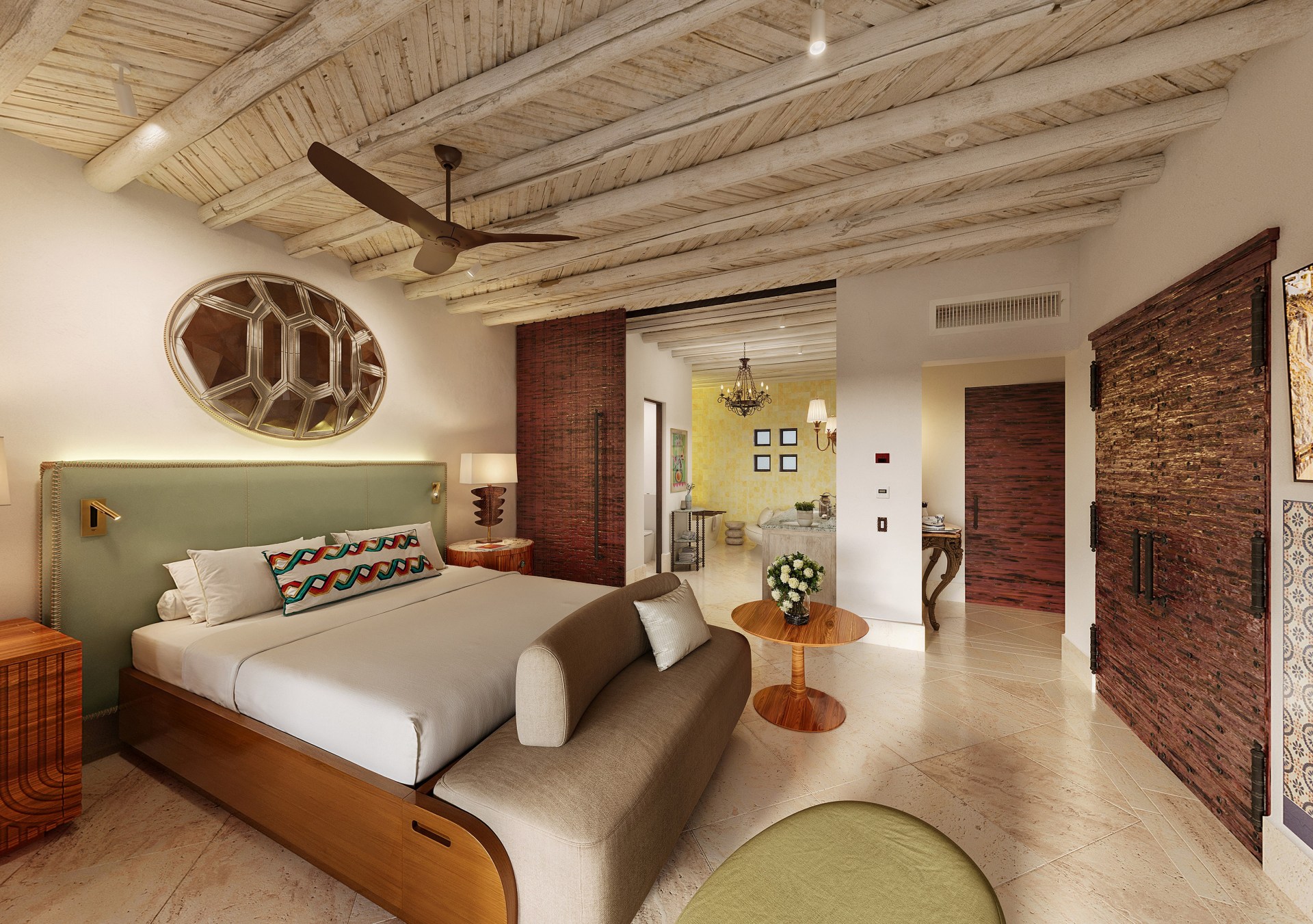 Waldorf Astoria Los Cabos Pedregal Guest Room, art hung on wall above bed headboard, ceiling fan, textured wood furniture with table lamp and binoculars sitting on top, wooden bed frame with bench at footer and a wooden round accent table, wall with decorative tile framing a fireplace with a television mounted above it